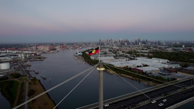 Aerial orbit, Aboriginal flag flying on top of Westgate Bridge, sunset