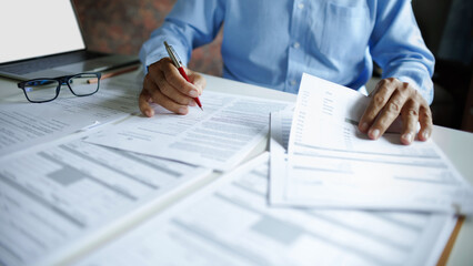 close up shot, accountant working with laptop reviewing the company's accounts and financial...