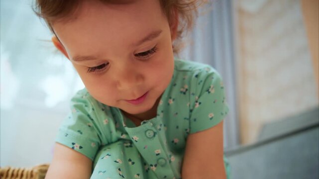 Joyful Moments of a Child Captured: A Young Girl's Delightful Expressions and Playfulness in Cozy Indoor Atmosphere
