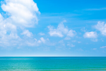 Obraz premium Tropical Nature clear sky and summer sea water under a clear blue sky with beautiful clouds and bright sunlight. Perfect for summer vacation and travel background