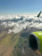 Beautiful view of airplane wing above Caribbean Sea with scattered clouds during flight departure from Curacao.