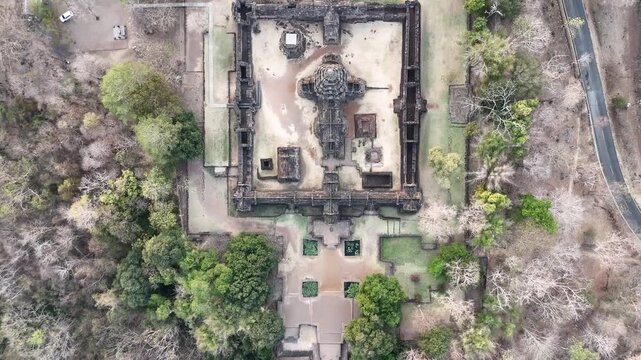 Aerial pull-back shot from Prasat Phnom Rung main sanctuary towards the entrance at sunset.
