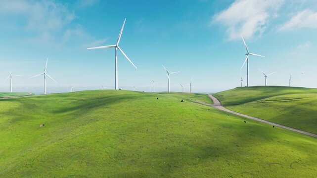 Ascending drone view captures the vast network of wind turbines near Altamont Pass, their rotating blades tracing patterns over golden grasslands and ridgelines outside Dublin California
