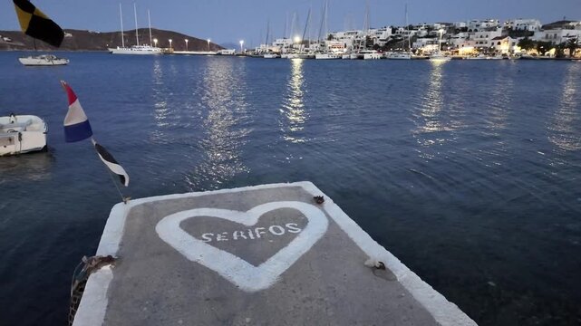 Serifos Island,View from the dingy dock towards the town quay and the town during dusk where moon and the lights of the town is visible. No people