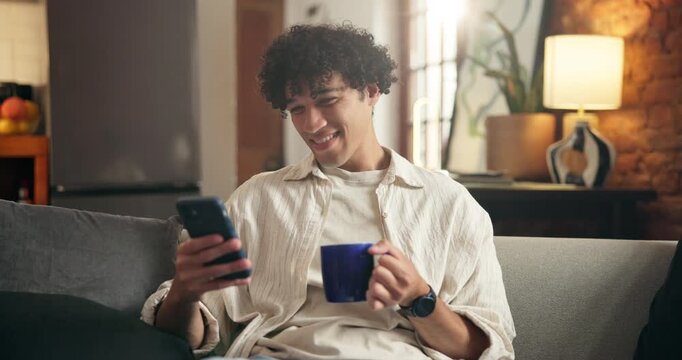 Home, coffee and happy man on sofa, cellphone for social media and message to contact. Connection, herbal tea or person on couch, relax and smartphone for online reading and website for entertainment