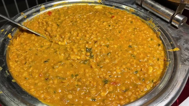 Aromatic Bengali Bhaja chana Dal garnished with golden-fried coconut and whole red chilies, served in a traditional celebratory setting.