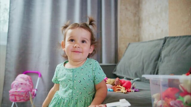 A Joyful Toddler Engaged in Play: Discovering a Treasure Trove of Colorful Toys and Surprises from a Box of Fun on a Cozy Couch Setting
