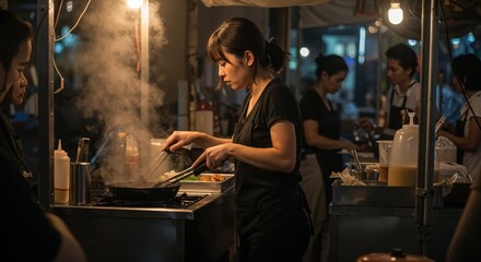 Obraz premium Sizzling Street Food Scene: Capturing the bustling energy of a street food vendor, amidst the rising steam and the warm glow of the lights, creating a sensory experience.