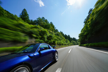 Naklejka premium A sleek sports car cruising along a scenic, tree-lined highway on a bright day