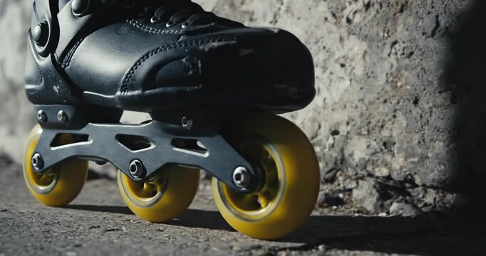 Close-up of a black roller skate on a gritty urban surface with shadows and textures