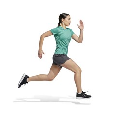 A woman in athletic gear is running with determination and focus on a white background.