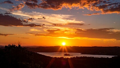 A serene sunset over a tranquil lake with vibrant orange sky