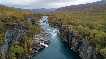 Obraz premium River canyon landscape, moody aerial view over wilderness scenery in Abisko National Park, Sweden, outdoor travel nature background