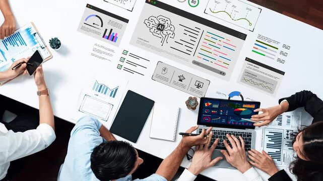 Collaborative Workspace with Data Visualization and AI Analysis on Table Amidst Diverse Team Engaged in Project Discussion and Planning Gluon.