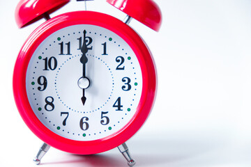 The classic red alarm clock is isolated on a white background