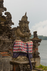 Fierce Wrapped Guardian Statue Overlooking Sacred Lake &ndash; Mystical Balinese Power