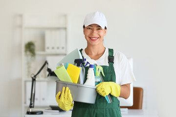 Female janitor with cleaning supplies in office