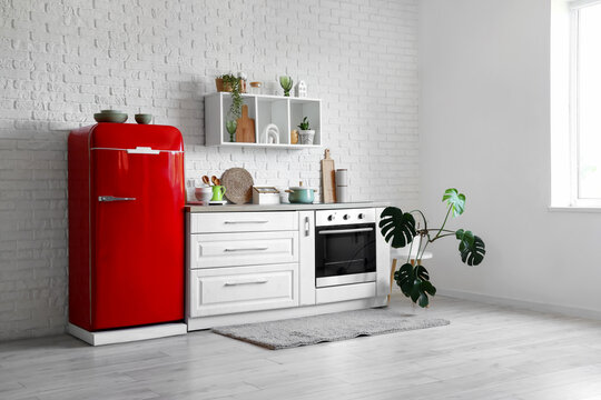 Interior of kitchen with red fridge, counter and shelf