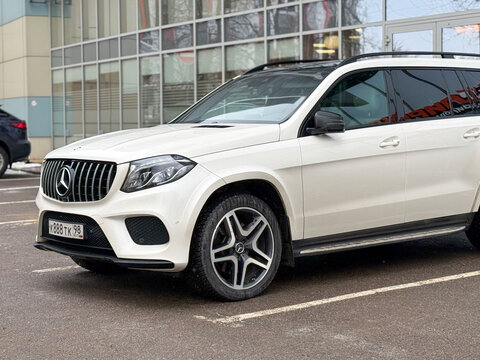 White Mercedes-Benz GLS I (X166) parked on street. Exterior of a German premium SUV car. Mercedes-Benz GLS parking lot in the center of the town. German automaker.