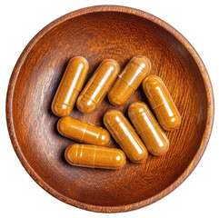supplement capsules on a small wooden plate isolated on transparent background