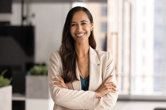 Pretty New Zealander woman, staff member, company executive manager dressed in elegant business suit posing with arms-crossed in modern office. Career, promotion, perspectives in professional sphere