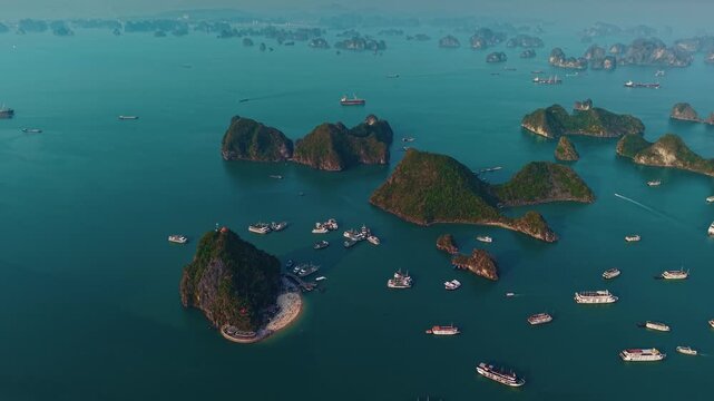 Aerial view Halong bay Titop Island at sunset with tourist cruise boats and limestone islands in Vietnam.