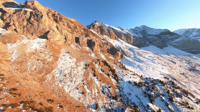 Cinematic High Altitude Flight Over Golden Grassy Slpes and Snowy Peaks