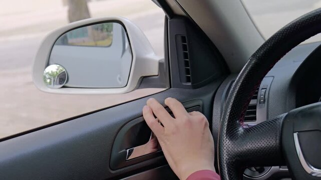 The driver adjusts the rearview mirror.