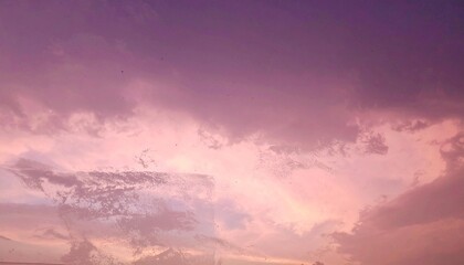 Dramatic pink and purple sky at dusk with hazy cloud cover