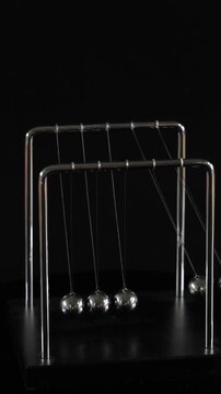 Vertical View of Newton's Cradle Metal Balls Swinging in Motion