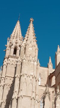 Detailed view of Palma Cathedral exterior in Palma Majorca Spain. Stunning Gothic architecture and spires under a bright blue sky.