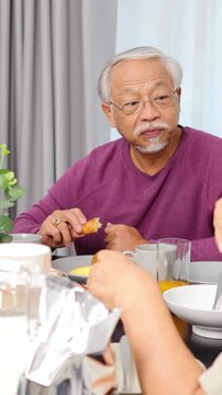 Three-Generation Asian Family Enjoying Breakfast Together at Home