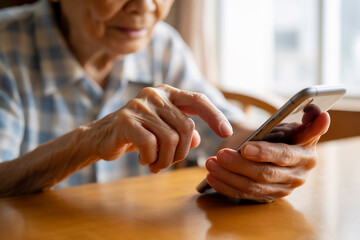 スマホを操作する高齢者の手元　Generative AI