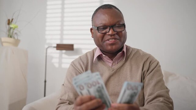 Financial success and wealth, portrait of average african american man with cash . Winner of lottery enjoying his winnings and counting new dollars banknotes, save money and rejoicing by savings