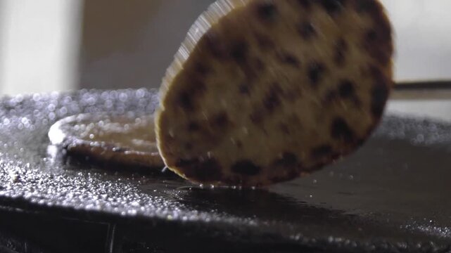Closeup shot of cooking Parantha on Pan. Local grain Bajra Roti.