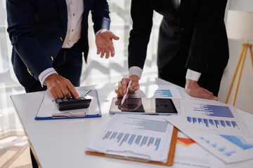 Naklejka na ściany i meble Two business people point to graphs and charts to analyze market data, balance sheet, account, net profit to plan new sales strategies to increase production capacity. 