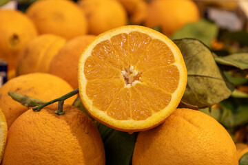 A close-up view of fresh half orange displayed with attached green leaves