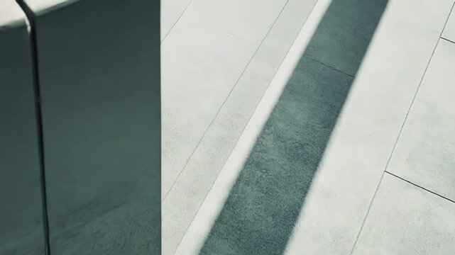 Minimalist concrete architecture creating a pattern of strong light and dark shadows, highlighting modern design, geometry, lines, and contrasting textures on a concrete floor