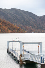 Fototapeta premium landscape view of Lake Chuzenji (Chuzenjiko) at Cruise Boat Passenger Terminal Nikko, Tochigi, Japan during autumn.
