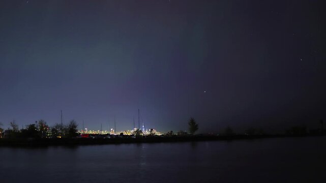 The real northern lights  - aurora borealis over Toronto from the Mississauga side at night against the backdrop of Lake Ontario is a very rare natural phenomenon.