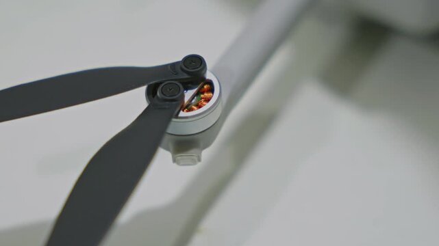 Close-up shot of drone motors slightly twitching during power on sequence. Quadcopter electronics initializing before flight, propellers not spinning yet. High quality 4k footage