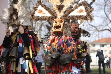 Fototapeta premium Zemen, Bulgaria - March 15, 2025: Masquerade festival Surva in Zemen, Bulgaria. People with mask called Kukeri dance and perform to scare the evil spirits.