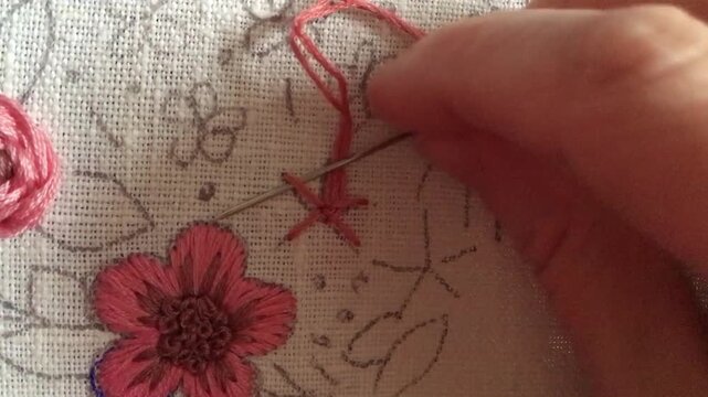 Part 2. Close-up tutorial of woven wheel rose embroidery with pink threads. Decorative stitched rose as part of Easter egg design on fabric. Step-by-step needlework technique for DIY,/