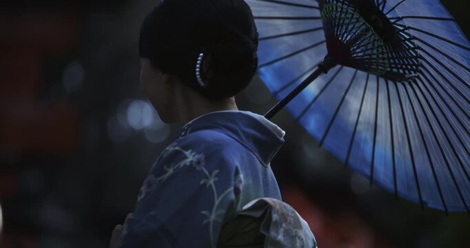 Silhouette of beautiful Japanese woman with umbrella turning around in slow motion
