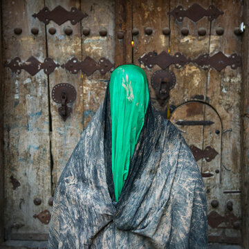 Iranian shiite muslim woman after rubbing mud on her chador during the Kharrah Mali ritual to mark Ashura, Lorestan, Khorramabad, Iran