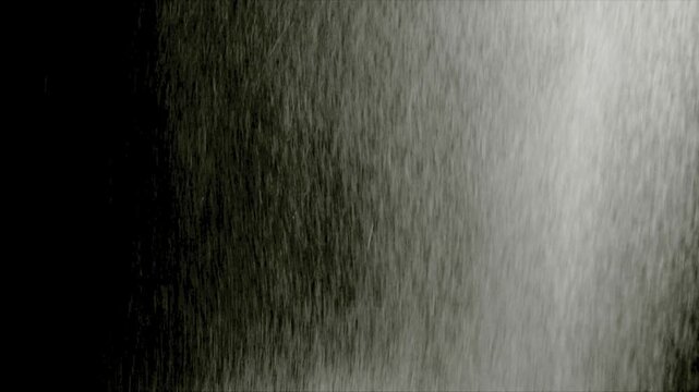 Realistic heavy rain falling against a black background for use as a cinematic weather overlay in post-production.