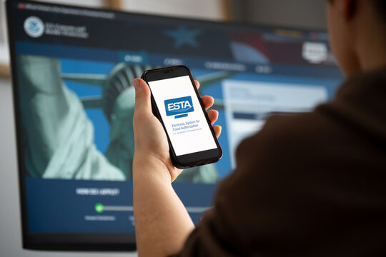Woman holding smartphone with ESTA Electronic System for Travel Authorization logo sign, filling form to travel to the United States under the Visa Program on February 17, 2026 in Krakow, Poland.