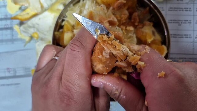 man preparing food by cutting jaggery in messy in dish 
