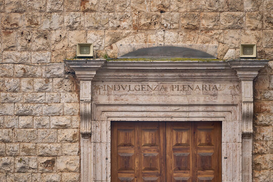 Stone church entrance displaying plenary indulgence inscription