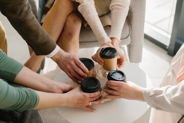 Naklejka premium Business team hands taking coffee to go